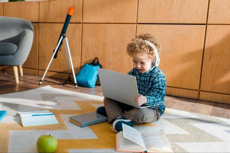 Ребёнок с ноутбуком и в наушниках