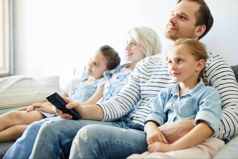 Семья смотрит телевизор в гостиной
