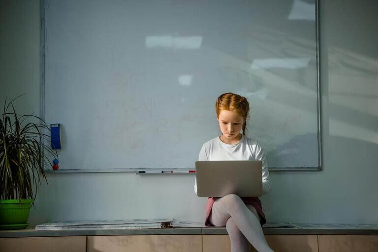 Девочка сидит с ноутбуком