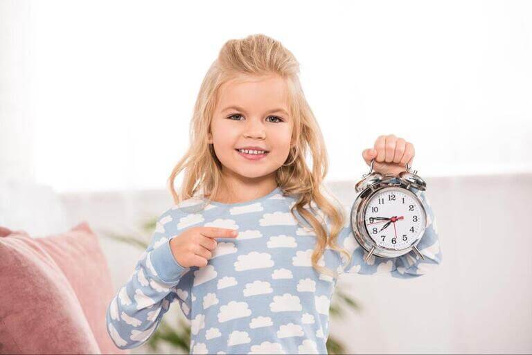 Маленькая девочка показывает на часы