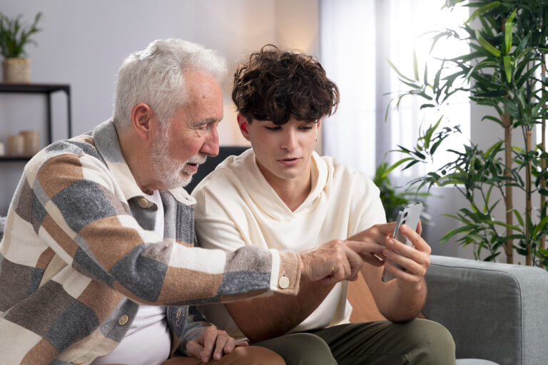 Подросток и взрослый мужчина вместе смотрят на телефон, обсуждая что-то важное
