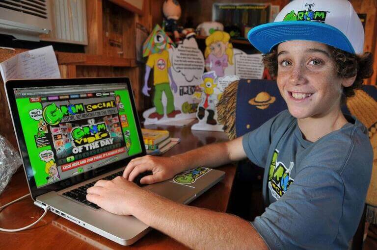 Подросток в кепке за компьютером